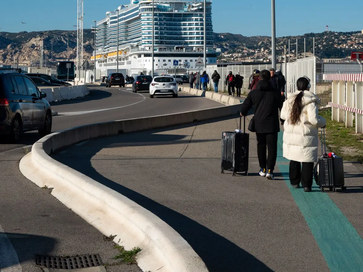 Travelers walking toward a cruise ship in port
