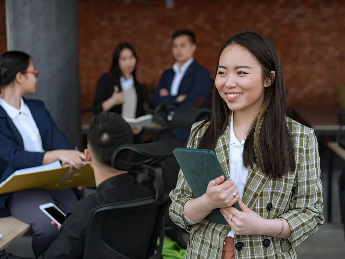 A smiling manager holding a tablet in an office