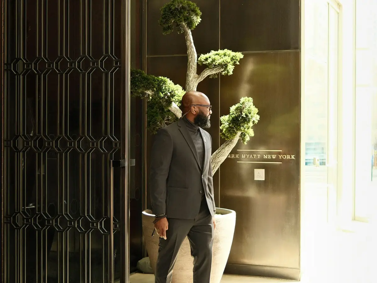 A manager in a suit standing at a hotel entrance