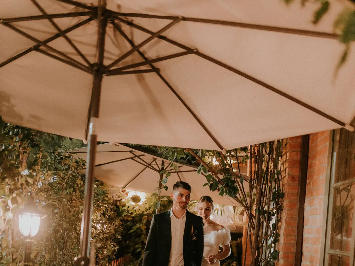 A couple arriving at an outdoor restaurant in the evening
